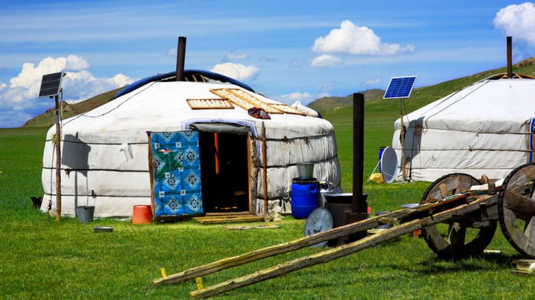Die Bewohner der Mongolei umgeben ihre einsamen Jurten mitten in der kahlen Steppe mit einem hohen Zaun und Reifen.